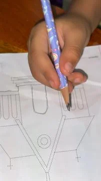 Young Child Learning To Trace Shapes With Pencil In Workbook Stockfoto's