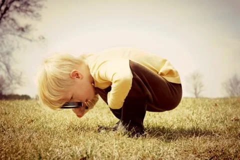 Young child looking through magnifying glass Stock Photos