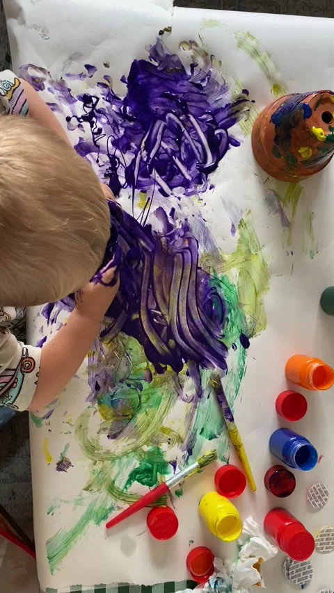 Young Child Making Messy Purple Finger Painting, Overhead View Stock Footage 340546584