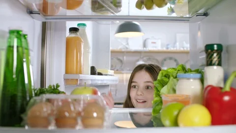 A young child opens a refrigerator full of healthy food and takes an apple. POV Stock Footage 100094111