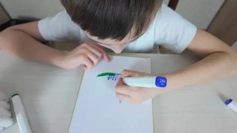 A young child passionately creating their own art with vibrant markers and Stock Footage 301692792