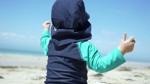 Young child playing with the sand at the beach - cinematic slow motion shot Stock Footage 95937115