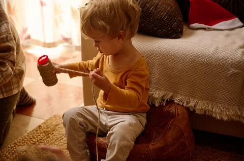 Young Child Playing With String And Yarn In Cozy Home Evening Scene Stock Photos