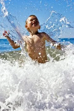 Young child playing in the waves Stock Photos