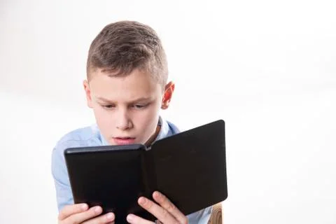 Young child reading strained in an e book reader on white background Stock Photos