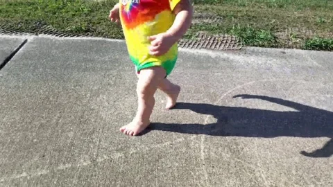 Young child running down sidewalk into sunset Vídeos de archivo 71164024