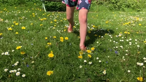 Young child running free in the springtime surrounded by wild flowers Stock Footage 132368933