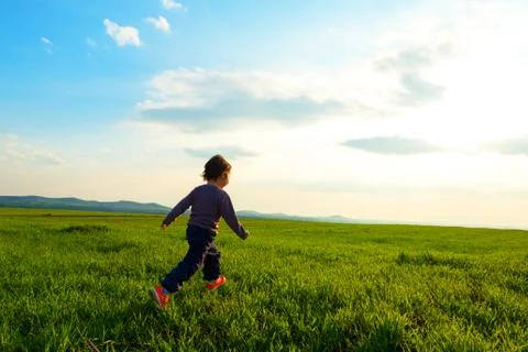 Young child running through a meadow Stock Photos