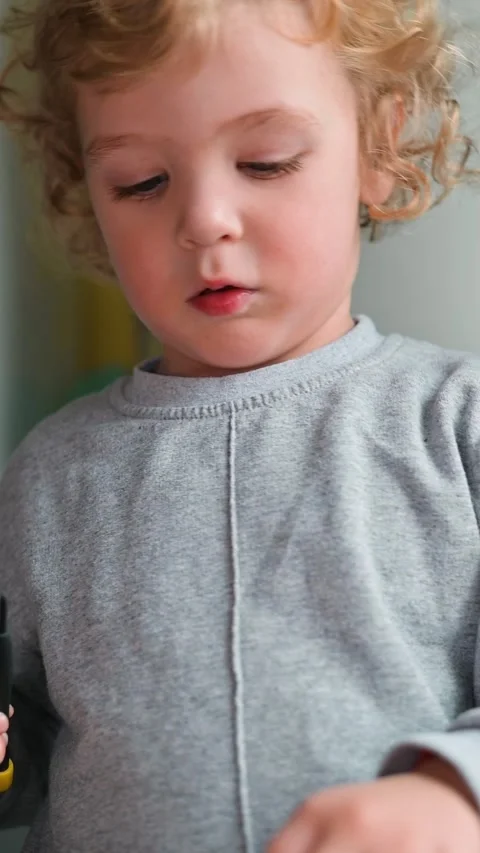 A young child is seen concentrating on manipulating small tools with both hands. 스톡 동영상 337112545