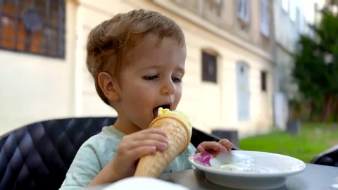 Young Child Sitting at Cafe Table Vidéo 345087625