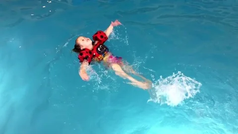 Young child splashes and swims across an indoor pool HD Stock-Footage 74098609