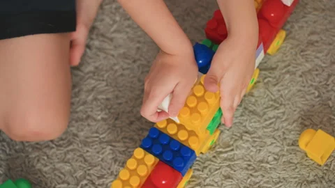 Young child stacking bright plastic blocks together. Young child engaged in 스톡 동영상 334707201