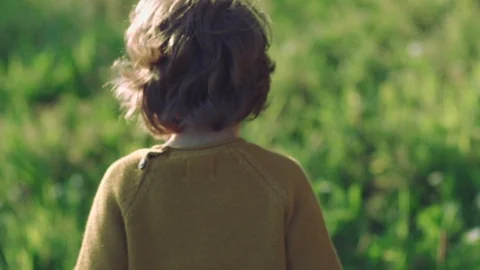 Young child standing on a green background in slow motion Stock-Footage 128846260