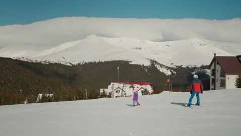 Young child struggling while learning to ski on trackhill on winter day. Stock Footage 299636449
