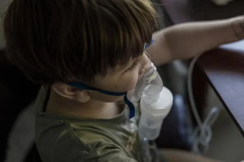 A young child using a nebulizer mask for asthma and respiratory treatment, .. Stock Photos