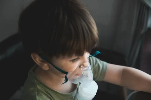 A young child using a nebulizer mask for asthma and respiratory treatment, .. Stock Photos