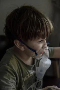 A young child using a nebulizer mask for asthma and respiratory treatment, .. Stock Photos