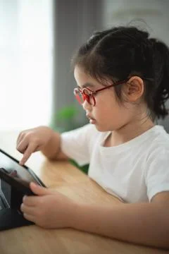 Young Child Using Tablet and Engaging with Digital Content Stock Photos