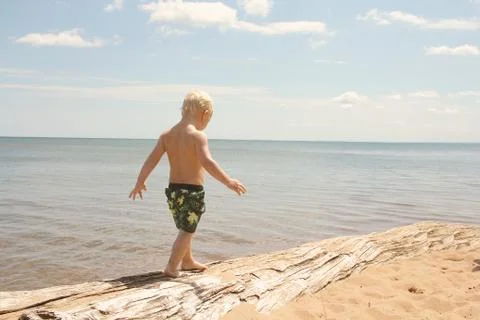 Young Child Walking on Beach Stock Photos