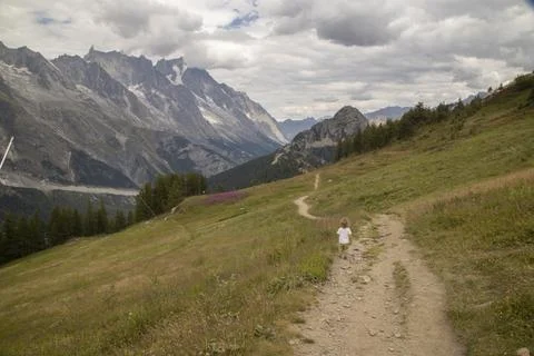 Young child walking on mountain path in alps Stock Photos