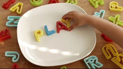 Young child writes PLAY with play clay letters Stock-Footage 75840198