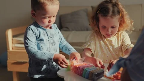 Young children focused on creative play with colorful craft materials, fostering Stock Footage 336464595