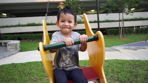 Young children happily playing spring chair in a park Video stock 37630070