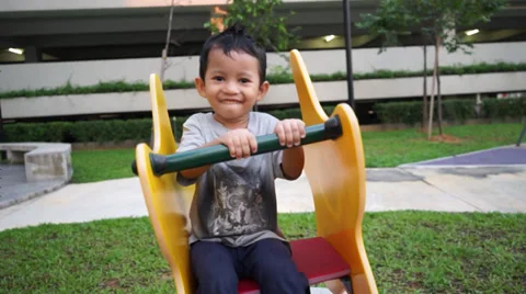 Young children happily playing spring chair in a park Stock Footage 37631111