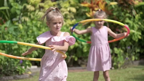 Young children sisters having fun with hula hoop outside in the park 스톡 동영상 139401929