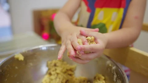Young child’s hands playfully mix cookie dough in a metal bowl Stock Footage 344577527