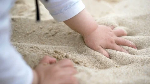 Young child's hands playing in the sand on a beach slow motion Stock Footage 95937008