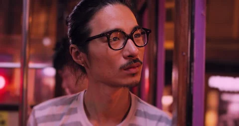 Young chinese man looking out window at city at night on Hong kong tram. Slow mo Stock Footage 201096531