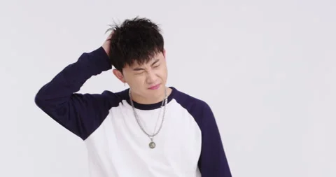 Young Chinese man scratching head,4K Stock Footage 247276428