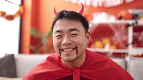 Young chinese man wearing devil costume having halloween party at home Stock Footage 237309857