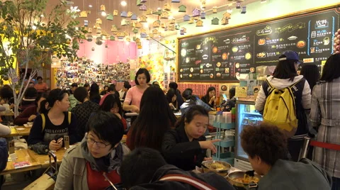 Young Chinese men and women eat in a busy trendy Korean restaurant in Shanghai Stock Footage