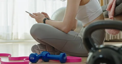 Young Chinese woman using smart phone after exercising,4K Stock Footage 228491853