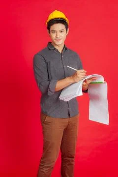 The young civil engineer is considering the construction plan. Portrait people c Stock Photos