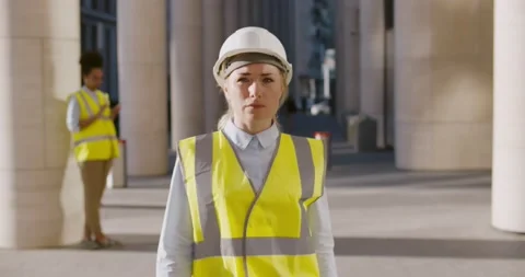 Young civil engineer in hardhat walking outside modern building Stock Footage 156444745