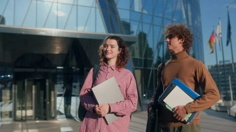 Young classmates standing together in front of modern glass campus Stock Footage 316091162