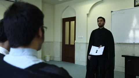 Young cleric gives a lesson inside of a class at Qom Seminary in Qom, Iran Stock Footage 168775987