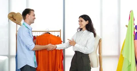 The young client shook hands with the designer in the tailor's room. Stock Photos