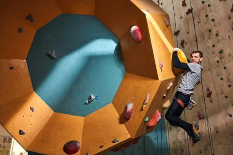 Young climber with physical disability training indoors, overhanging at Stock Photos