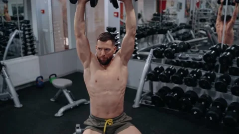The young coach shows how to correctly lift the dumbbells with his hands from a Stock Footage 156859126