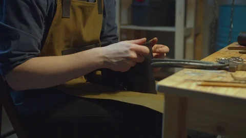 Young cobbler makes a handmade boot Stock Footage 127831687