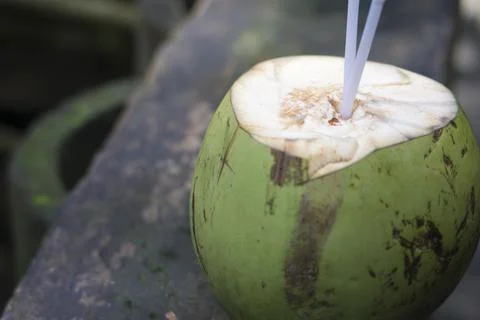 Young coconut is ready to drink with two straws. Good illustration of traditi Stock Photos