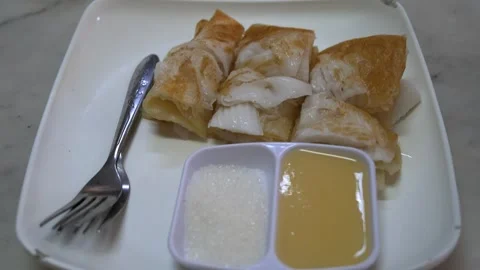 Young coconut roti is placed in a plastic plate with stainless steel cutlery Stock Footage 275592459
