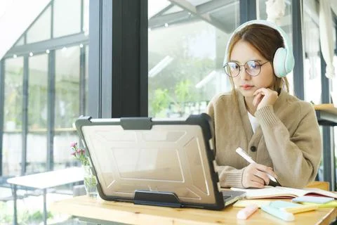 Young collage student using computer and mobile device studying online.. Stock Illustration