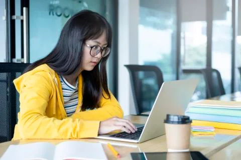 Young collage student using computer and mobile device studying Stock Photos