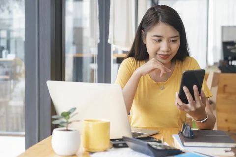 Young collage student using computer and mobile device studying online. Stock Photos
