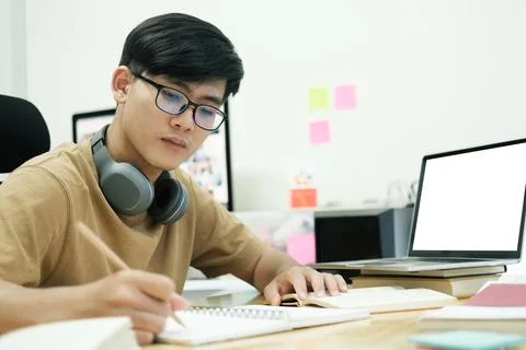 Young collage student using computer and mobile device studying Stock Photos